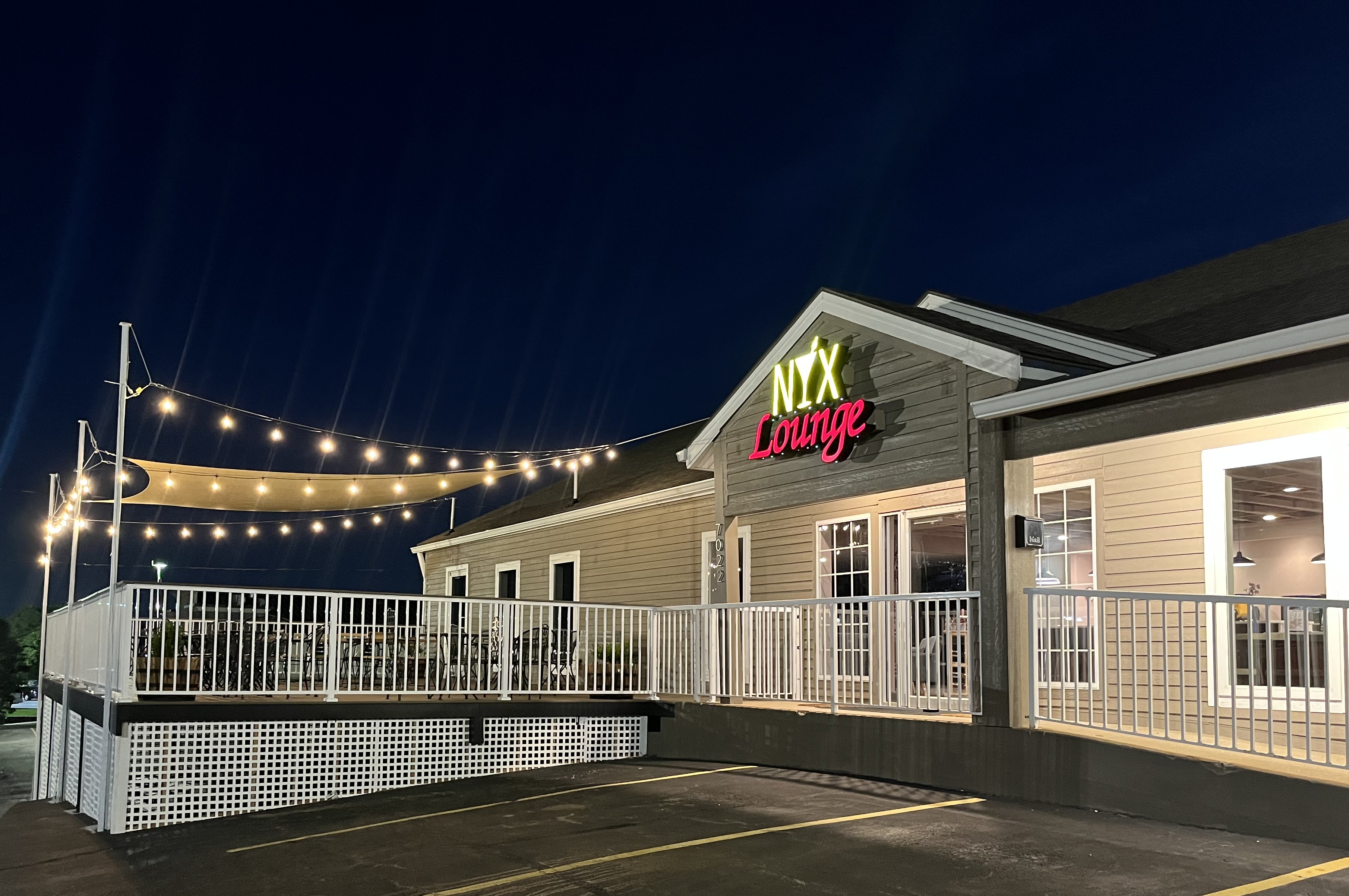 Exterior deck at NYX Spirits & Lounge in Gladstone, Missouri with string lights and evening seating.